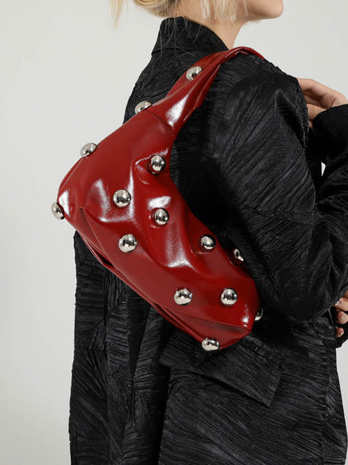 Bolso femenino de hombro con detalles metálicos decorativos
